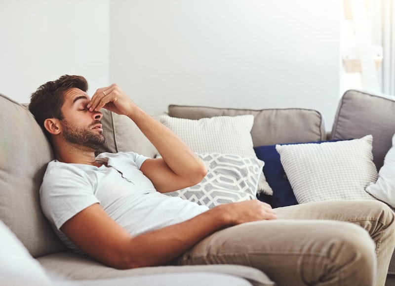 Stressed man on couch because furnace is acting up